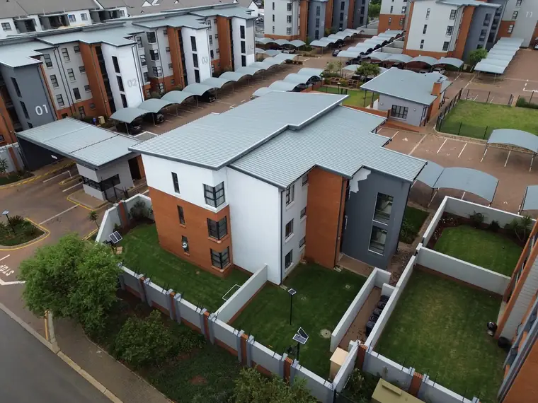 Aerial of a residential complex with painted facades and metal roofs